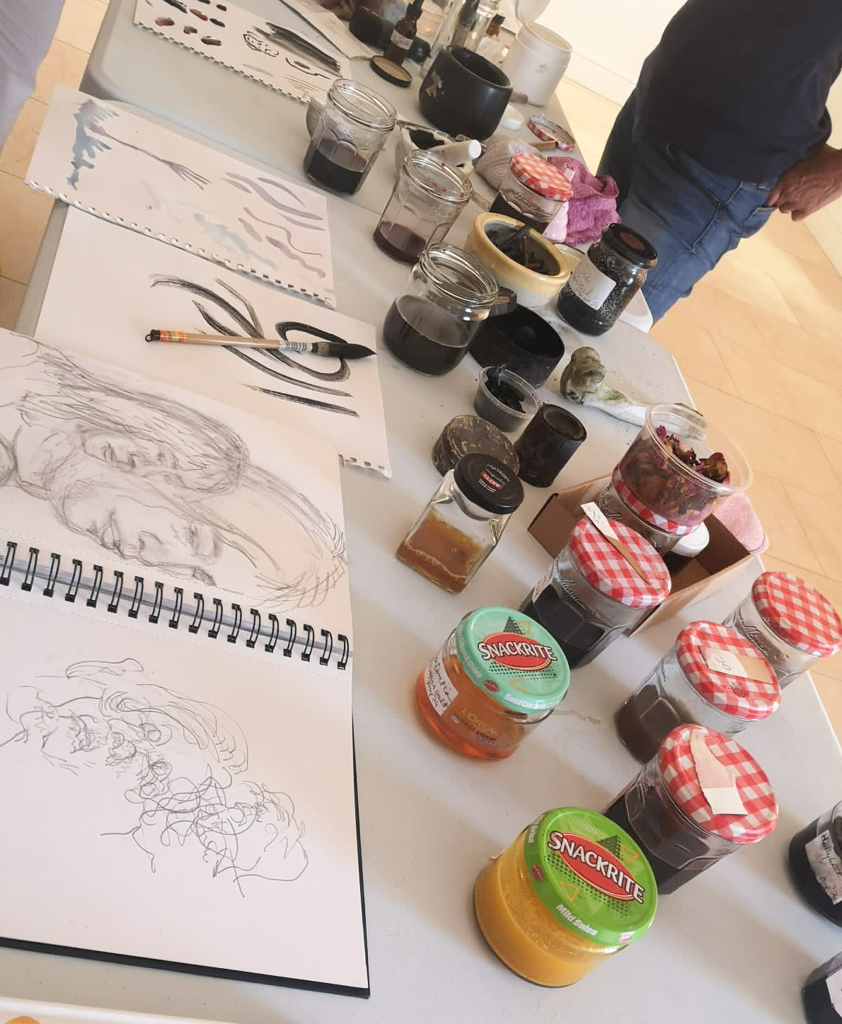 Homemade inks and pigments in recycled jars arranged for a demonstration